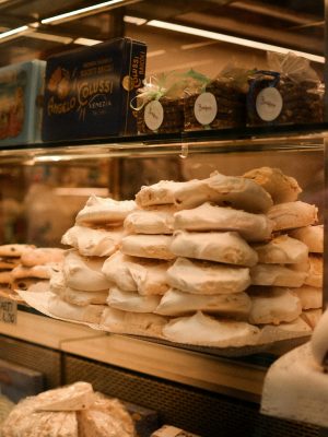 A close-up of traditional Italian pastries elegantly displayed in a glass cabinet in Veneto, Italy.