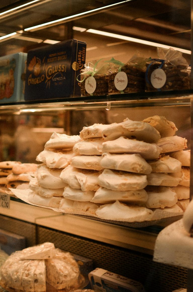 A close-up of traditional Italian pastries elegantly displayed in a glass cabinet in Veneto, Italy.