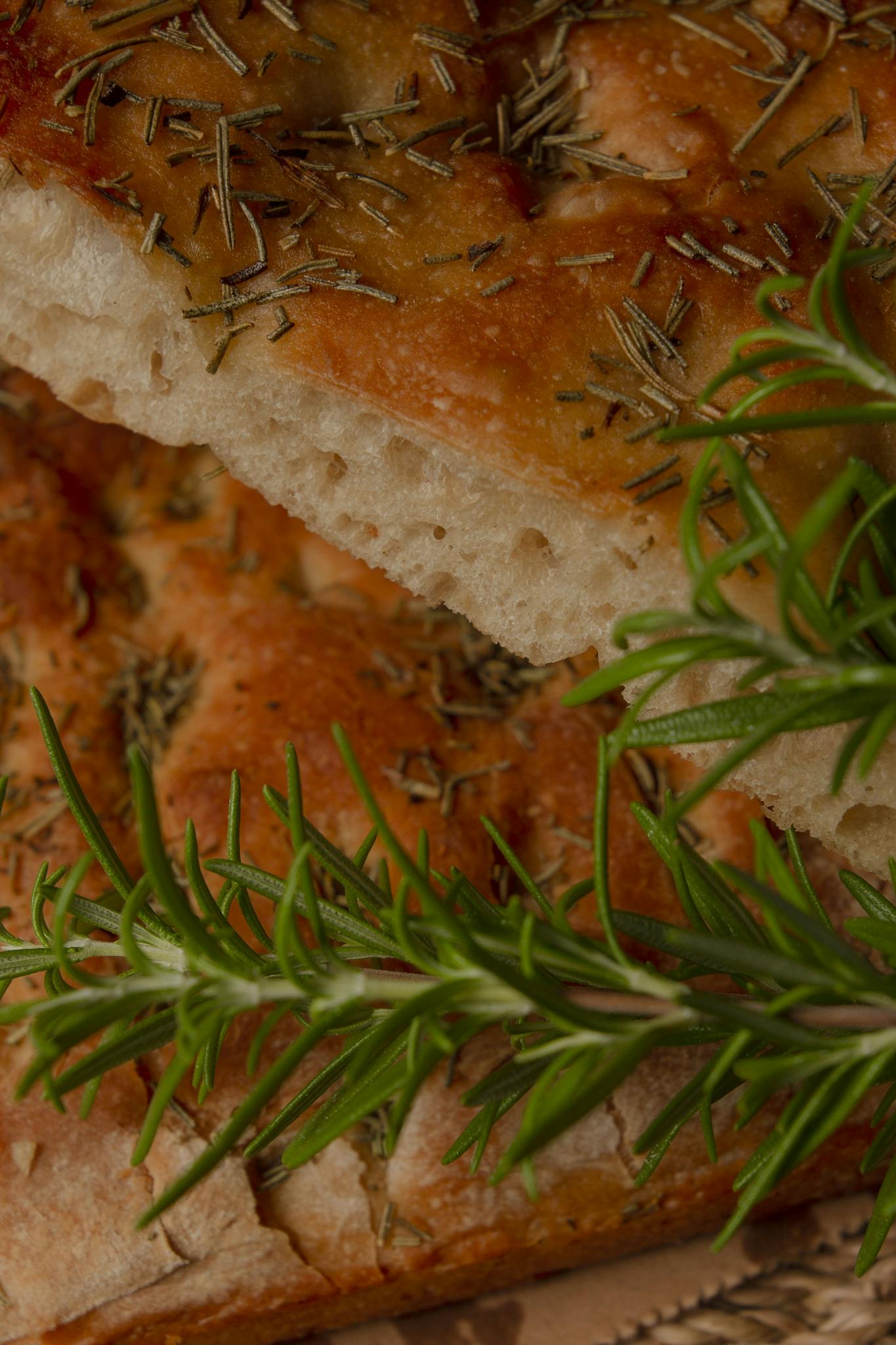 Appetizing focaccia bread topped with rosemary and herbs, perfect for culinary uses.