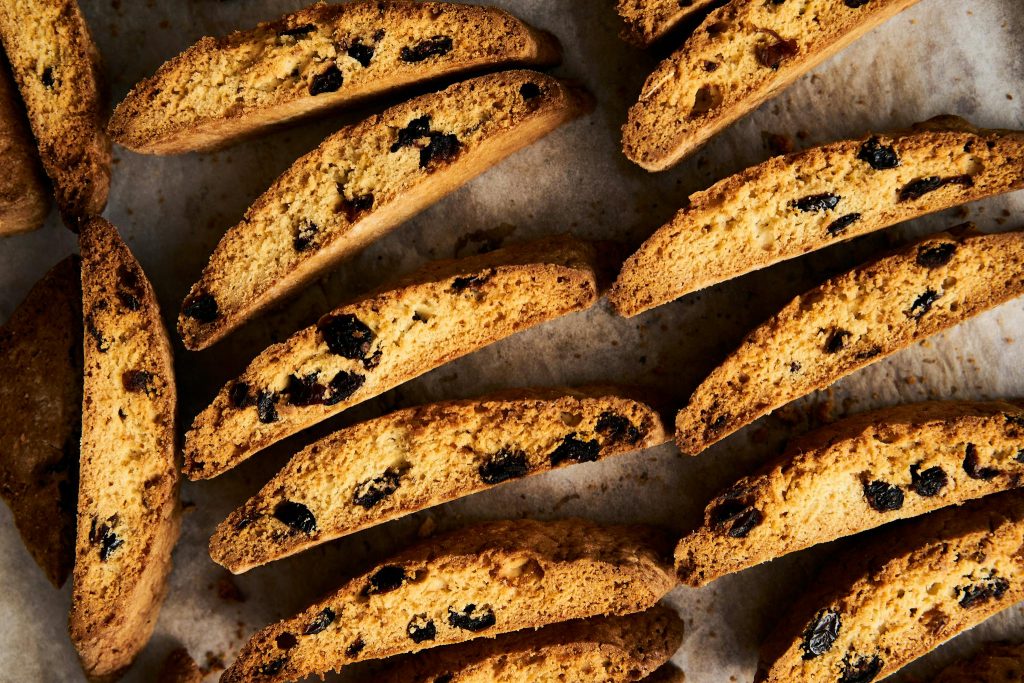Top view of freshly baked biscotti cookies with raisins on parchment paper.